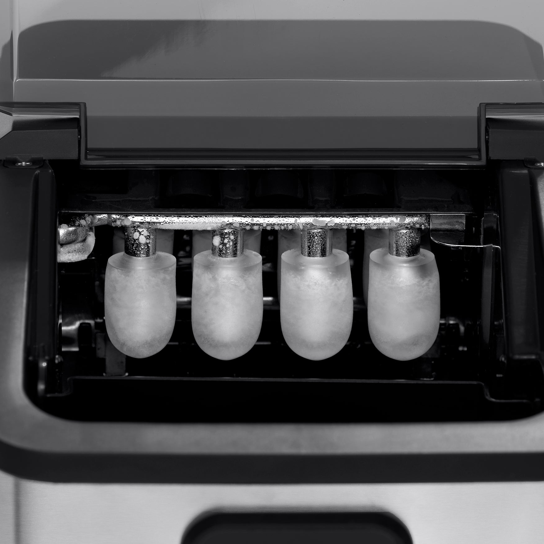 A close-up photo of bullet ice cubes being formed by the Newair AI-110SS ice maker.